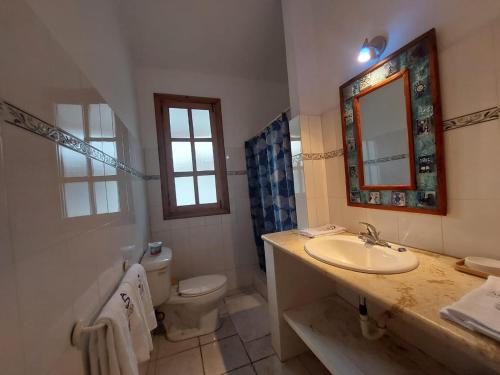 uma casa de banho com um lavatório, um WC e um espelho. em Sueño caribeño em La Laguna