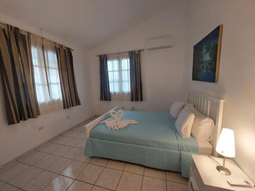 um quarto com uma cama com uma flor em Sueño caribeño em La Laguna