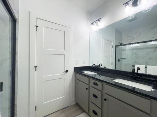 a bathroom with a white door and a sink and a mirror at Majesty - Work Friendly & Near Downtown in Jeffersonville