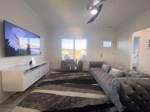 a living room with a couch and a flat screen tv at Majesty - Work Friendly & Near Downtown in Jeffersonville