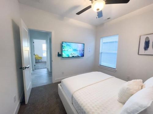 a white bedroom with a bed and a ceiling fan at Majesty - Work Friendly & Near Downtown in Jeffersonville