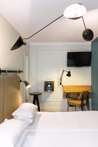 a hotel room with a bed and a desk at Hôtel Silky by HappyCulture in Lyon