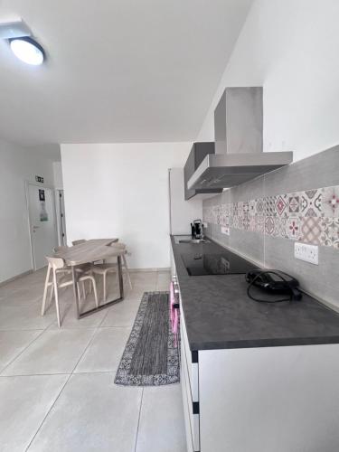 a kitchen with a counter top and a table at Sunshine Court Apartment No 1 in Sliema