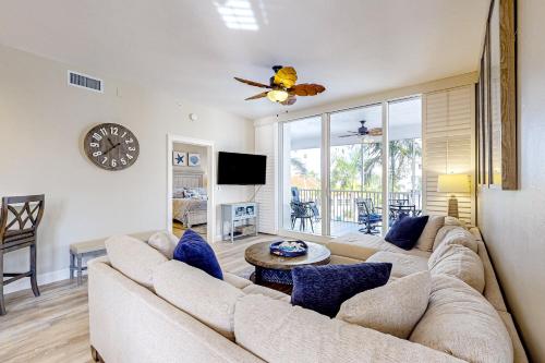 a living room with a large couch and a clock at Luxury Condo in Regatta in Naples