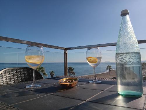 uma mesa com dois copos de vinho e uma garrafa em Alojamiento Iberia Playa em Estepona