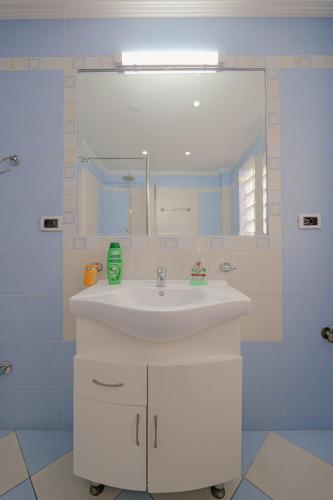 a bathroom with a white sink and a mirror at Villa Xika in Sarandë