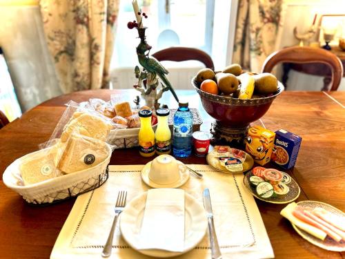 a table with a basket of bread and a bowl of fruit at Hotel Boutique Casa Conde in Zafra