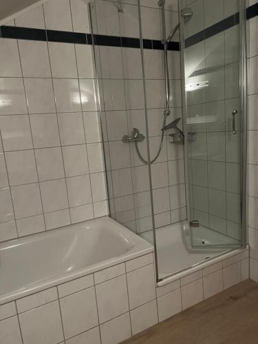 a bathroom with a tub and a shower with a glass door at Am Mühlenkamp daheim 7, 8, 14 in Heringsdorf