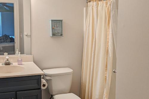 a bathroom with a white toilet and a sink at Bethany Bay Condos in Ocean View