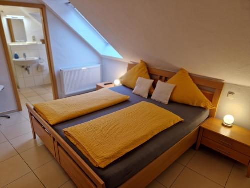 una camera da letto con un grande letto con cuscini gialli di Weingut u. Gästehaus Becker a Platten
