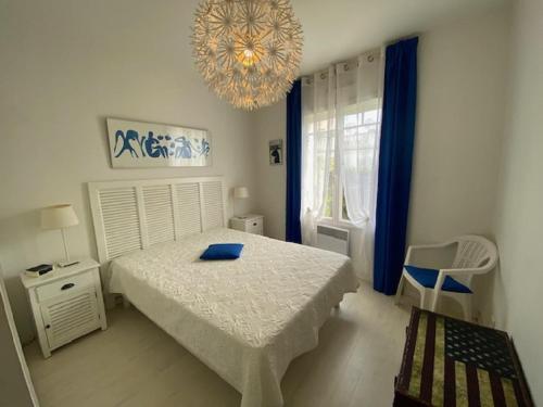 サン・ジル・クロワ・ド・ヴィにあるL'Esterelleのベッドとシャンデリアのある寝室