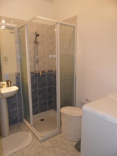 une douche avec une porte vitrée dans une salle de bain dans l'établissement L'Esterelle, à Saint-Gilles-Croix-de-Vie