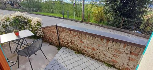 a brick wall with a table and chairs on a patio at Casa Pulci in Grinzane Cavour
