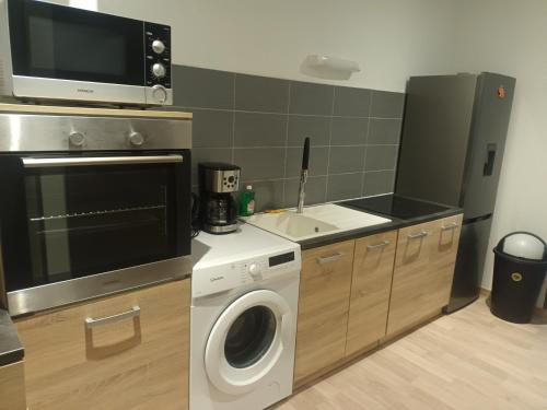 une cuisine avec un lave-linge et un micro-ondes dans l'établissement MOUNT LAVINIA, à La Fère
