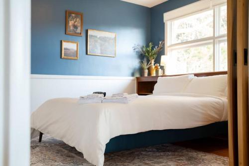 ein Schlafzimmer mit einem großen Bett mit blauer Wand in der Unterkunft The Mulberry on Bragg in Raleigh