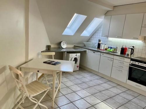 ベルンにあるQuiet Attic-Apartment Bern Centerのテーブルと椅子付きのキッチンが備わります。