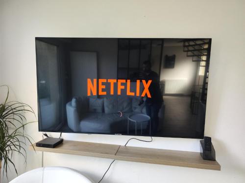 un televisor con las palabras netflix en la pantalla en Le PATIO GARONNE maison 6 personnes, climatisé, Netflix, en Portet-sur-Garonne