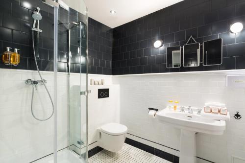 y baño con ducha, aseo y lavamanos. en Hôtel Silky by HappyCulture, en Lyon