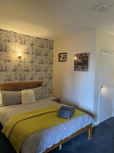 a bedroom with a bed with a green blanket at The Half Moon Inn Rushall IP21 4QD in Pulham Saint Mary the Virgin