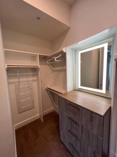 a walk in closet with a mirror and a dresser at Midtown High Rise Escape in Houston