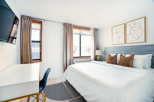 a bedroom with a large white bed and a desk at 75-4B Duplex 3BR Brand new W D Prime UES in New York