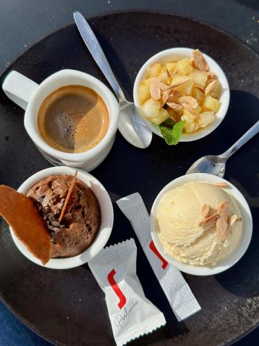 a table with three plates of food and a cup of coffee at Logis Hôtel & Restaurant Le Vert Bocage in Franqueville-Saint-Pierre