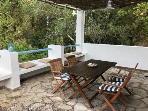 un patio con tavolo, sedie e letto di Sea View Apartment in the Greek Nature a Gouviá
