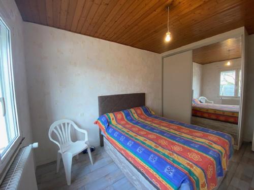 a bedroom with a bed and a chair and a window at Maison 6 personnes au calme quartier Val in Le Fenouiller