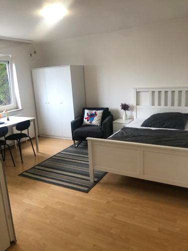 ein Schlafzimmer mit einem Bett, einem Stuhl und einem Tisch in der Unterkunft Apartment 6 am Stuttgarter Flughafen-Messe in Leinfelden-Echterdingen