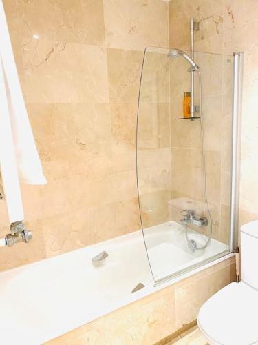 a bathroom with a shower and a tub and a toilet at Roda Golf. Poolside apartment in Murcia