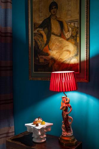 a red lamp on a table in a room with a painting at Palazzo Roma - The Leading Hotels of the World in Rome
