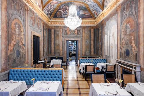 a restaurant with tables and chairs and a chandelier at PALAZZO ROMA in Rome