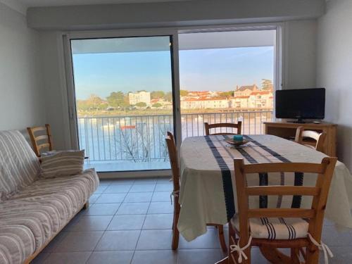 - un salon avec une table, un canapé et une fenêtre dans l'établissement Appartement face port pour 4 personnes, à Saint-Gilles-Croix-de-Vie