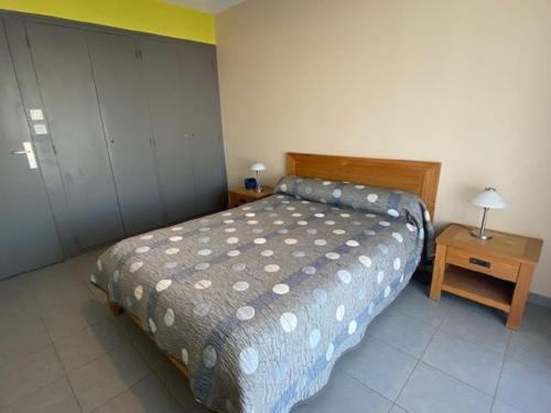 une chambre avec un lit et une table avec une lampe dans l'établissement Appartement face port pour 4 personnes, à Saint-Gilles-Croix-de-Vie