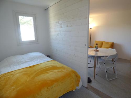 une chambre avec un lit, une table et une fenêtre dans l'établissement Le New Port, à Saint-Gilles-Croix-de-Vie