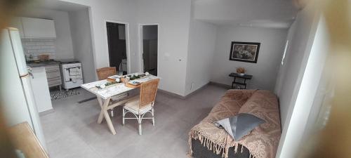 a living room with a table and a bed and a kitchen at Casinha da paz in Jaú