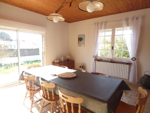 une salle à manger avec une grande table et des chaises dans l'établissement Les Rochers, à Saint-Gilles-Croix-de-Vie