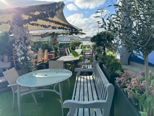 a row of benches and tables on a patio at Rafayel Hotel & Spa in London
