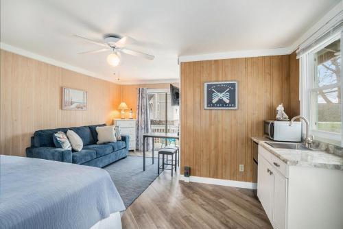 uma sala de estar com um sofá azul e uma cozinha em Waters View Inn em South Haven