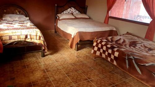 a bedroom with two beds and a window at Cabaña Villa San Lorenzo in Tomatas