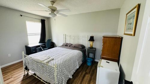 una camera con letto e ventilatore a soffitto di 2 private rooms in a quiet neighborhood can book up to 4 people a Orlando