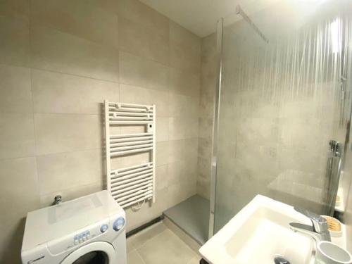 une salle de bain avec une machine à laver et un lavabo dans l'établissement L'Amiral, à Saint-Gilles-Croix-de-Vie