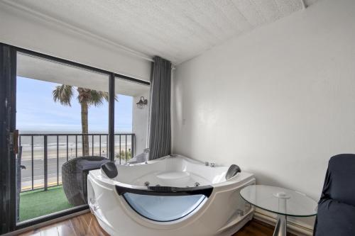 a bath tub in a room with a large window at Bello condominio con vista al mar, jacuzzi interno in Galveston