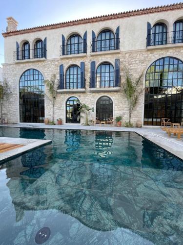 a large swimming pool in front of a building at Rhea Alaçatı Boutique Hotel in Alacati