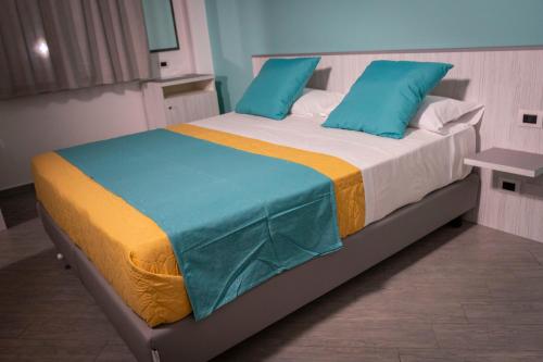 una camera da letto con un grande letto con cuscini blu di Tenuta Pietravera a Furnari