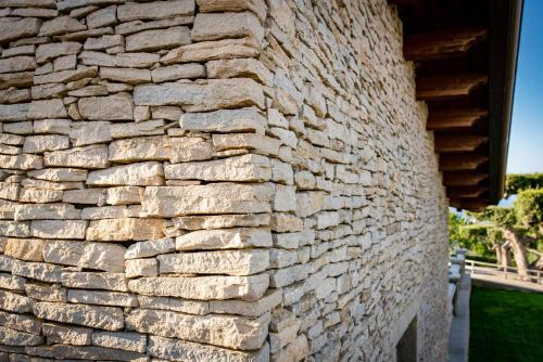 a stone wall next to a house at Tenuta Pietravera in Furnari