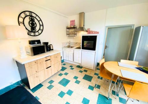 une petite cuisine avec une table et un micro-ondes dans l'établissement Le Bellevue #2 - 5 personnes - Futuroscope -La Conciergerie, à Jaunay-Clan