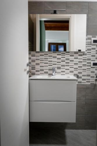a bathroom with a white sink and a mirror at Tenuta Pietravera in Furnari