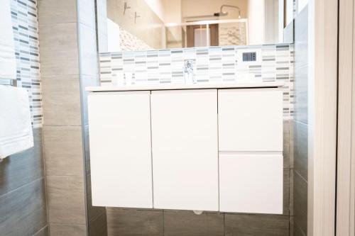 a bathroom with white cabinets and a sink at Tenuta Pietravera in Furnari