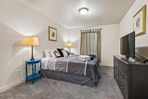 Un dormitorio con una cama y un televisor de pantalla plana. en Charming Private Twnhome w/ Large Fenced Yard (58), en Meridian